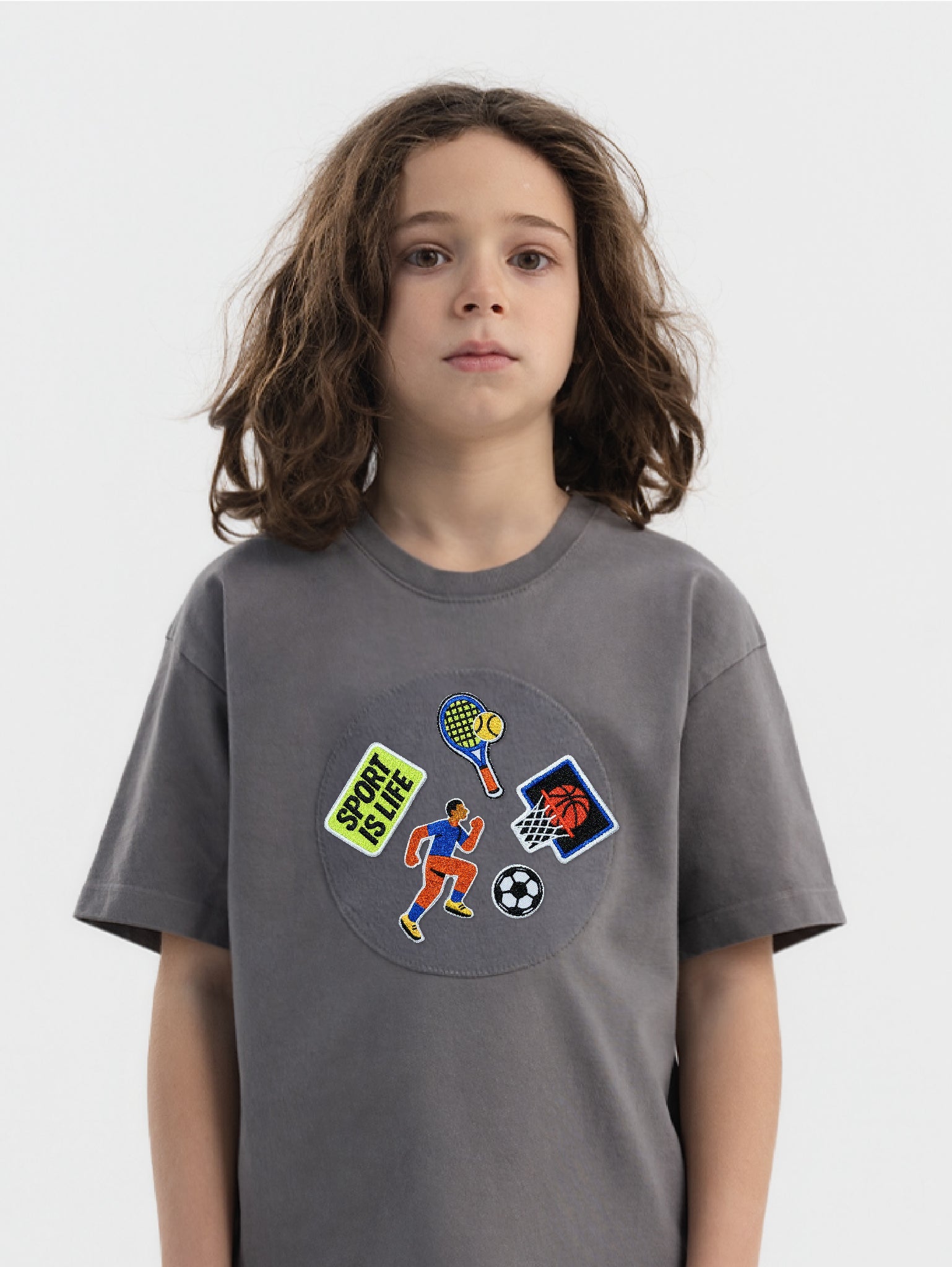 Kid wearing the Sport Is Life patch set on a Hahaha tee