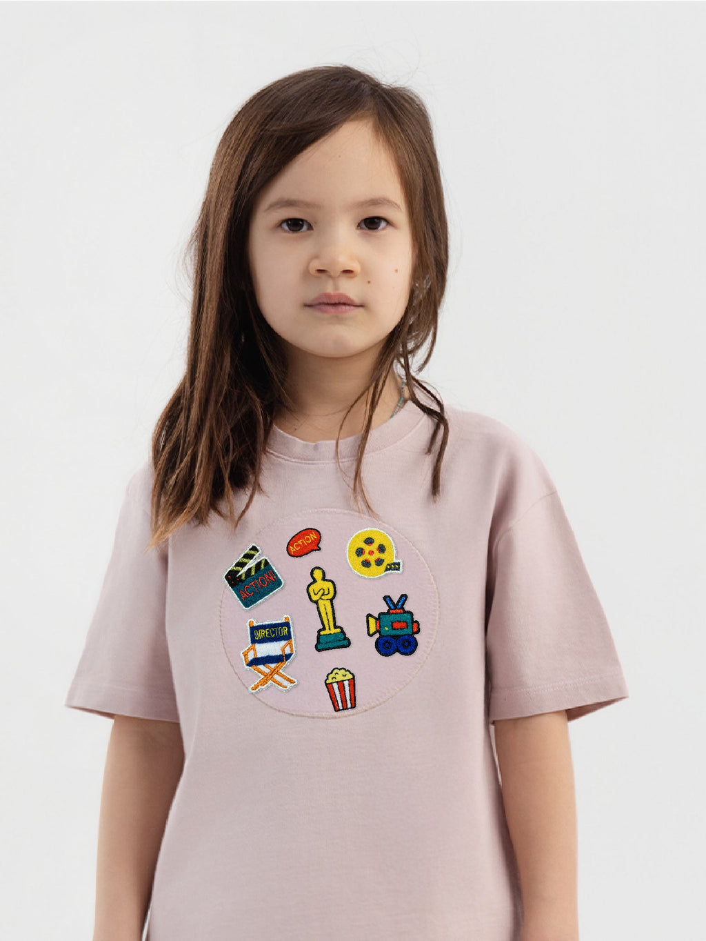 Kid wearing the Little Director patch set on a Hahaha tee