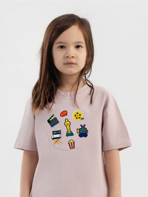 Kid wearing the Little Director patch set on a Hahaha tee