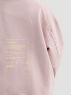 Close-up of circular swappable patch zone texture on dirty pink Hahaha organic cotton kids hoodie
