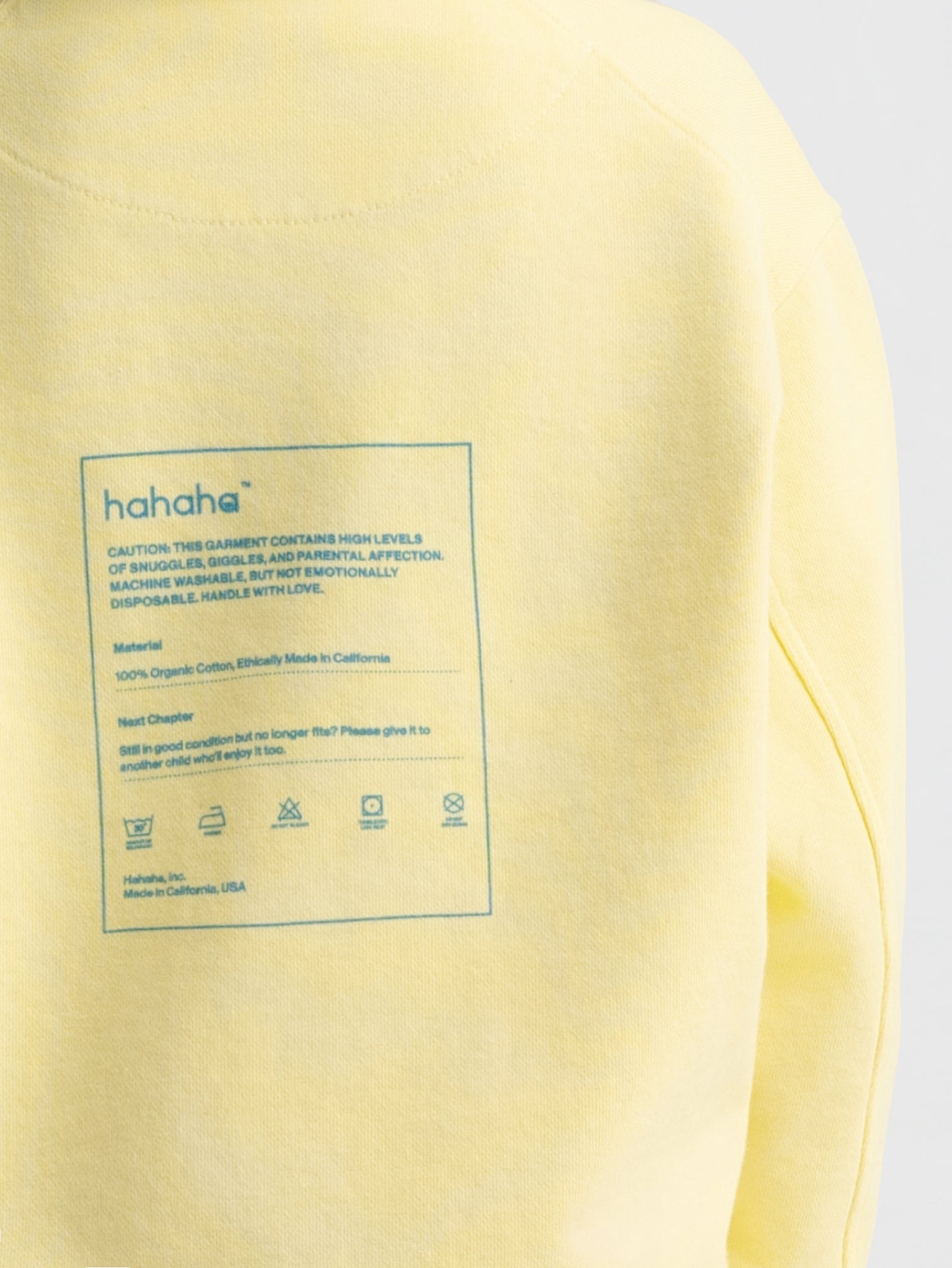 Close-up Hahaha kids hoodie back label - CAUTION CONTAINS SNUGGLES GIGGLES AND PARENTAL AFFECTION