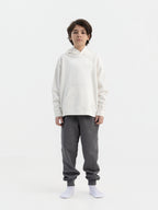 Child wearing off white Hahaha organic cotton hoodie with joggers, front view, made in Los Angeles