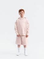 Child wearing dirty pink Hahaha organic cotton hoodie with joggers, front view, made in Los Angeles
