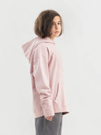 Child wearing dirty pink Hahaha hoodie with collectible patches on swappable circular patch zone